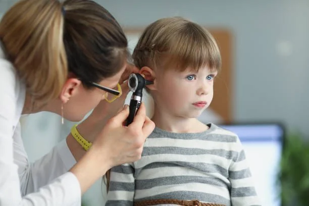 Médica examinando o ouvido de uma criança com um otoscópio